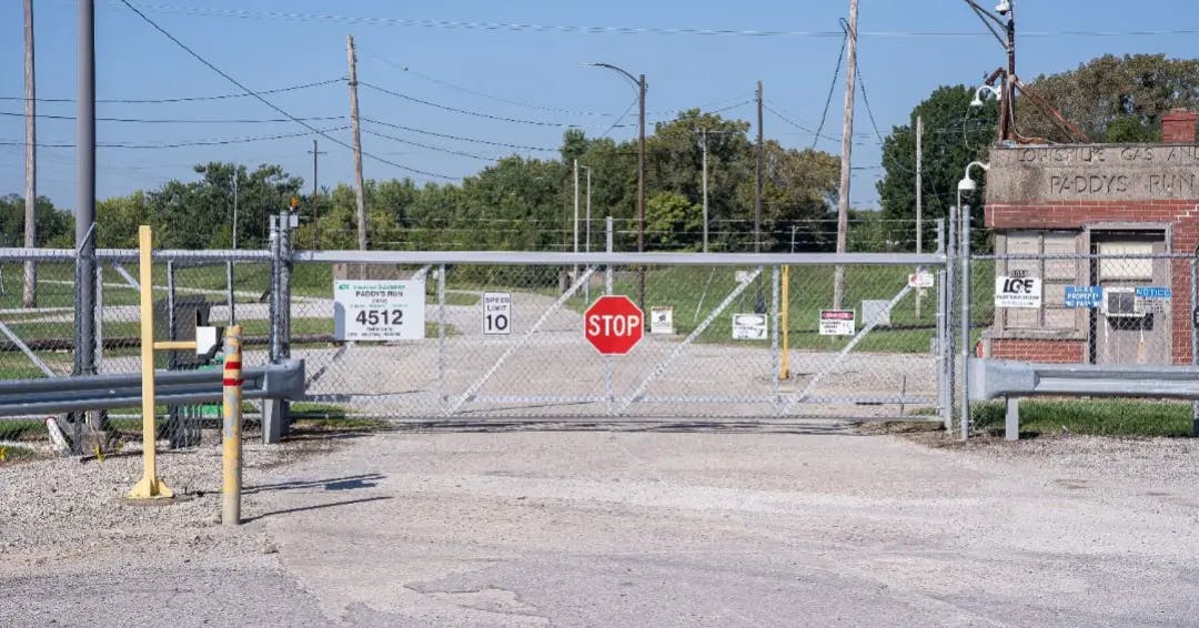 Stop sign in front of fence in factory